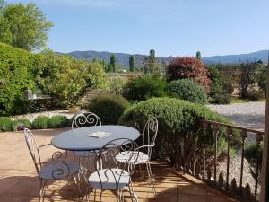 a patio with a table and chairs on a balcony at La Parenthèse in Lauris