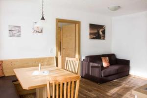 a living room with a table and a couch at Apart Alpin in Hippach