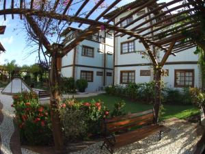 een tuin met een bank voor een gebouw bij Apartment Terraces Porto Das Baleias in Praia do Forte