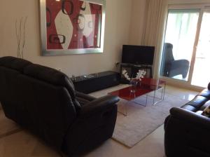 a living room with two couches and a table at Agua Marina exklusiv apartment in Benalmádena