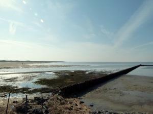 ein Pier am Strand neben dem Wasser in der Unterkunft Haus Deichblick in Husum