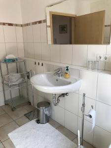 a white bathroom with a sink and a mirror at Ferien- und Winzerhof Ute Braun in Nordheim +45 photos