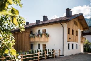 ein Haus mit einer Holzfassade und einem Zaun in der Unterkunft Chalet Dolomit in St. Lorenzen