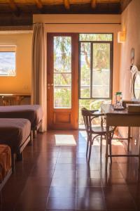 a bedroom with two beds and a table and a door at Patio Alto in Tilcara