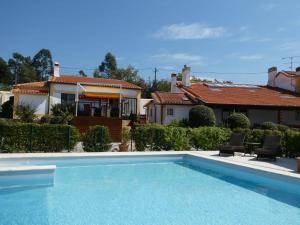 a swimming pool in front of a house at Vida-Vi, Country House and B&B in Santa Catarina