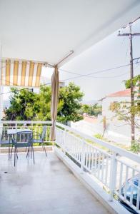 a balcony of a house with a table and chairs at House Charistos in Neos Marmaras