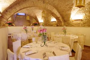 jadalnia ze stołami i krzesłami z białymi obrusami w obiekcie Antica Dimora alla Rocca w mieście Trevi