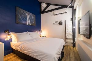 una camera da letto con un letto grande e una parete blu di Twilight House a Jiufen
