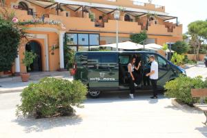 dos personas están saliendo de una furgoneta verde en Hotel Medusa, en Lampedusa