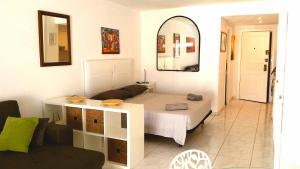 a room with a bed and a couch and a mirror at Charming Suite ocean view heated pool in Los Cristianos +24 photos