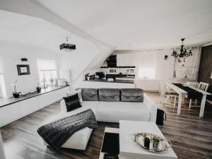 a white living room with a couch and a kitchen at Apartament Rynek Pniewy in Pniewy