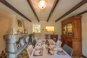 a dining room with a table and a fireplace at ty dreux entre terre et mer in Saint-Thégonnec