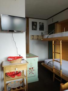 Cette petite chambre comprend des lits superposés et un bureau. dans l'établissement Piccolo Igloo, à Falcade