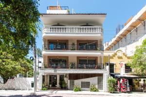 an apartment building with balconies on a city street at Suites Corazon in Playa del Carmen