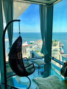 a swinging chair in a room with a large window at SEA TOWERS PENTHOUSE 23-24 Two-Floors Sea View Panoramic Terrace 110m2 !!! jacuzzi in Gdynia