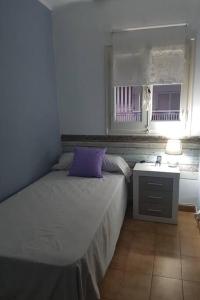 - une chambre avec un lit doté d'un oreiller violet dans l'établissement Apartamento excepcional,piscina y 100m de la playa, parking gratis!!, à Salou