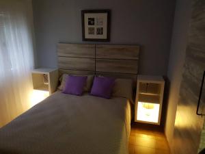 - une chambre avec un grand lit et des oreillers violets dans l'établissement Apartamento excepcional,piscina y 100m de la playa, parking gratis!!, à Salou