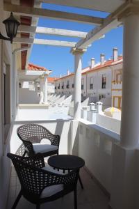 un patio con 2 sillas y una mesa en el balcón en Baleal Holiday House, en Baleal