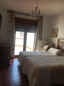 um quarto com uma cama, um sofá e uma janela em Hotel-Apartamento Carolina y Vanessa em San José