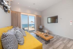 MpoukarisにあるValtes Luxurious Apartmentsのリビングルーム(黄色のソファ、テーブル付)