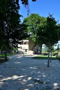 ein Parkplatz mit Bäumen vor einem Gebäude in der Unterkunft Podere Codone in Carnaiola