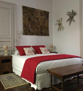 a bedroom with a large bed with a red blanket at Châtel Rose in Blois