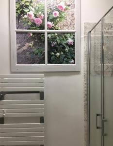 un baño con una ventana con flores. en Châtel Rose, en Blois