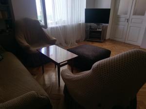 - un salon avec deux chaises, une table et une télévision dans l'établissement Guest House Vista, à Sighnaghi