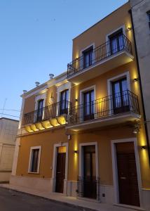 a yellow building with balconies on the side of it at Saint George's House Appartamenti & Spa in Pachino