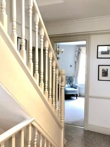 - un escalier dans une maison avec un escalier blanc dans l'établissement Lauras Townhouse Apartments Lansdown Slope Townhouse, à Bath