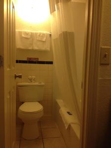 uma casa de banho com um WC branco e uma luz em Battlefield Inn Springfield em Springfield