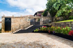 a stone building with a gate and flowers at Pazo de Esposende in Esposende