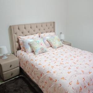 een slaapkamer met een groot bed met kussens bij Studio Des Nations Miramar Mohammedia in Mohammedia
