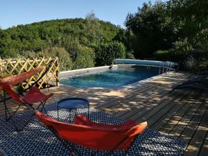 een zwembad met 2 stoelen en een hangmat op een terras bij Chez Karine et Julien in Cahors