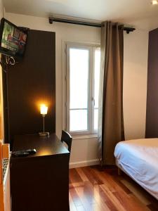 - une chambre avec un bureau, un lit et une fenêtre dans l'établissement Luxelthe, à Paris