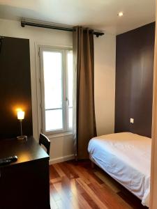 - une chambre avec un lit, un bureau et une fenêtre dans l'établissement Luxelthe, à Paris