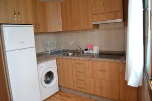 a kitchen with a sink and a washing machine at Junonia Marítimo in Playa de Santiago +4 photos