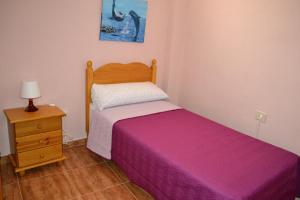 a small bedroom with a bed and a night stand at Junonia Marítimo in Playa de Santiago