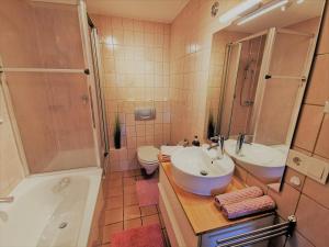 Un baño con dos lavabos, una ducha y una bañera. en Ferienwohnung am Eichwald, en Immenstadt im Allgäu 43 fotos más