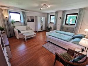 Un dormitorio con una cama y una sala de estar. en Ferienwohnung am Eichwald, en Immenstadt im Allgäu
