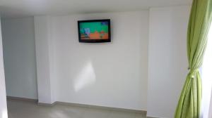 uma televisão numa parede num quarto em Hotel Santafe Suite em Bogotá