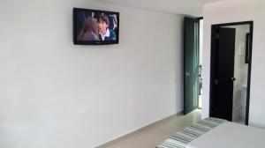 a tv on the wall of a bedroom at Hotel Santafe Suite in Bogotá