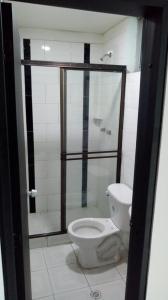 a bathroom with a toilet and a shower stall at Hotel Santafe Suite in Bogotá