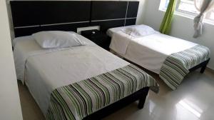 two beds in a small room with at Hotel Santafe Suite in Bogotá