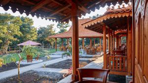 a wooden pavilion with chairs and tables in a park at ParLezo in Lengkoajang