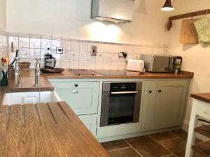 a kitchen with white cabinets and a counter top at Lauras Townhouse Apartments Garrard's Retreat in Bath