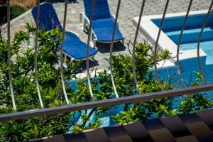 duas cadeiras azuis sentadas ao lado de uma piscina em Vacation house near sea & beaches with HEATED POOL & BBQ em Orebić