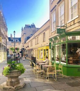 een straat met tafels en stoelen en een café bij Lauras Townhouse Apartments Garrard's Retreat in Bath
