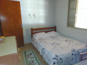 a small bedroom with a bed and a table at CHACARA PRIMAVERAS in Jarinu