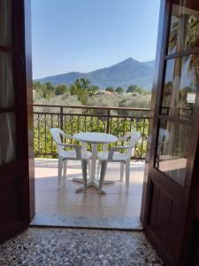 een tafel en stoelen op een balkon met uitzicht bij Hotel George in Chrysi Ammoudia